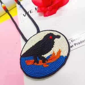 Collier pendentif oiseau noir perlé fait main, design circulaire avec détails bleus, blancs et oranges, pour un usage artistique et culturel - Product Image 6