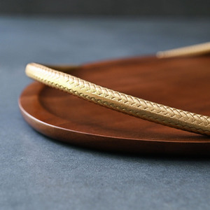 Plateau de service rond en bois exquis, avec une finition bois riche et des poignées courbes dorées texturées distinctives en forme de serpent, pour le service. - Product Image 4