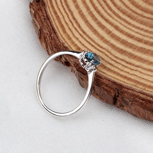 Vente en gros de bagues à trois pierres en argent sterling 925 massif avec accent en topaze bleue de Londres ovale naturelle et CZ, Memoria Jewels - Product Image 3