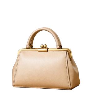 Parece ser un bolso beige con cierre estructurado, similar en diseño al bolso con asa trenzada de la marca Bag. - Product Image 1