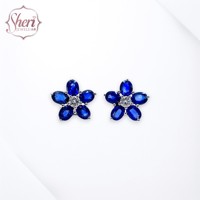 Pendientes de tuerca de oro blanco macizo de 18 quilates para mujer Sheri Jewels, estilo flor simple, con zafiro azul y diamante ovalado, engaste de garra, regalo