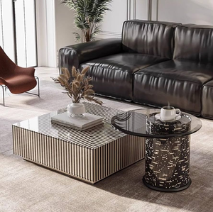 Mesa de centro minimalista redonda con incrustaciones de hueso de marfil y un patrón de bloques subtil, soportada por un marco de patas cruzadas de metal de latón delgado. - Product Image 4