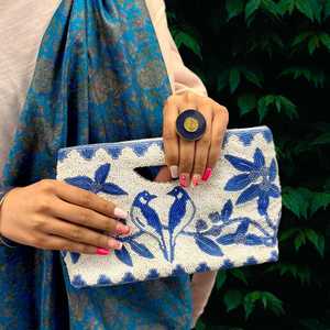 Pochette rectangulaire faite à la main avec broderie florale bleue sur fond textile blanc pour les occasions festives - Product Image 1