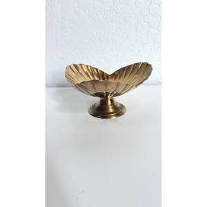 La superficie dorada pulida de un tazón de latón refleja la luz como un pequeño sol dorado sobre la mesa. - Product Image 5