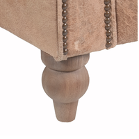 Canapé Chesterfield haut de gamme deux places en cuir avec dossier profond matelassé, accoudoirs roulés, structure en bois massif, assise confortable pour salon.