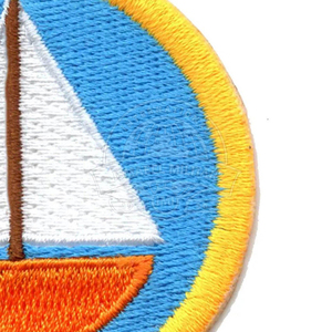 Patch thermocollant circulaire avec motif de voilier brodé, fond bleu, coque orange, voiles blanches, bordure jaune - Product Image 3