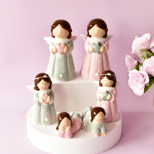 Petit ange en porcelaine rose et gris avec des ailes tenant un cœur et une étoile - Product Image 1