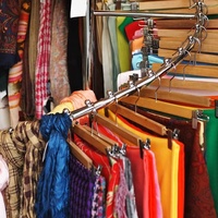 Porte-vêtements en spirale métallique avec base blanche et barre de suspension chromée pour support d'extensions capillaires écologique en magasin