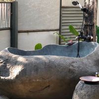 Baignoire ovale traditionnelle d'extérieur en pierre de rivière naturelle gris foncé, taille personnalisée, avec drain central, pour villa, sécurité garantie, en bois