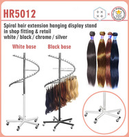 Porte-vêtements en spirale métallique avec base blanche et barre de suspension chromée pour support d'extensions capillaires écologique en magasin